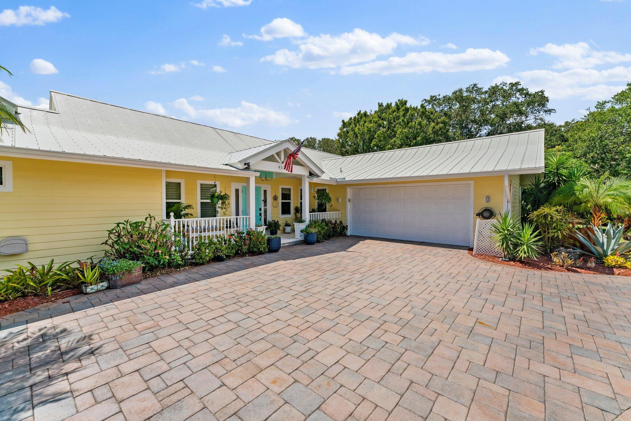 4120 Southeast Whiticar Way Stuart, FL 34997 - Photo 3 of 60 a front view of a house with a yard and potted plants