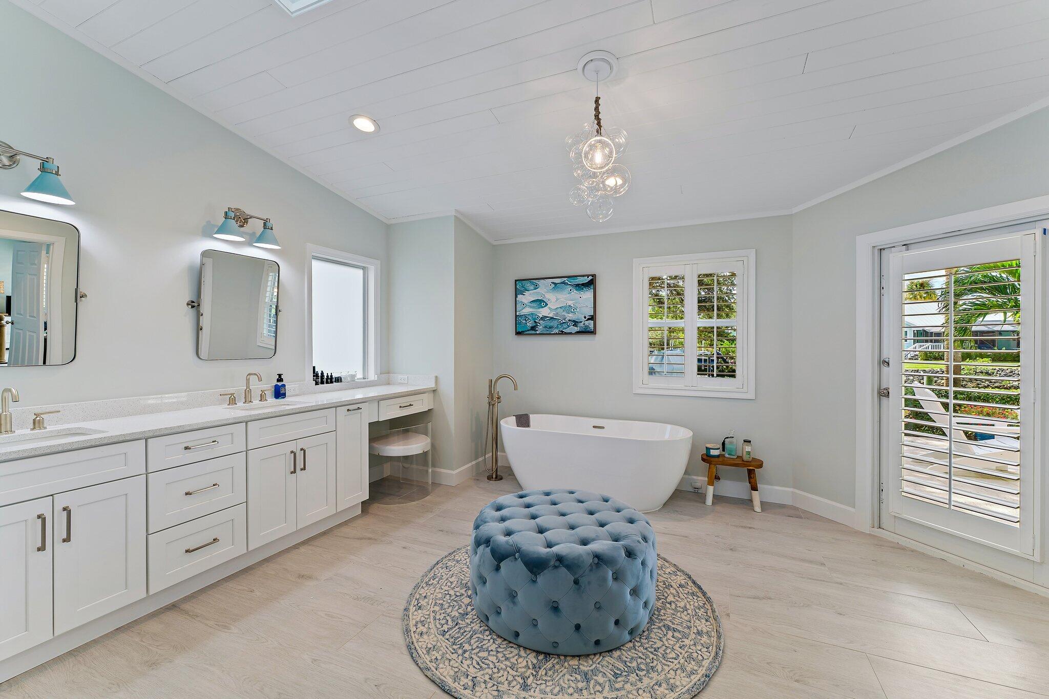 4120 Southeast Whiticar Way Stuart, FL 34997 - Photo 32 of 60 a spacious bathroom with a double vanity sink a mirror and a bathtub