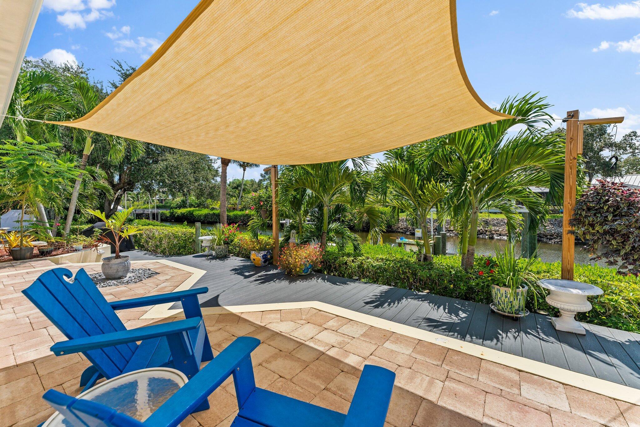 4120 Southeast Whiticar Way Stuart, FL 34997 - Photo 45 of 60 a view of a patio with table and chairs potted plants and palm trees