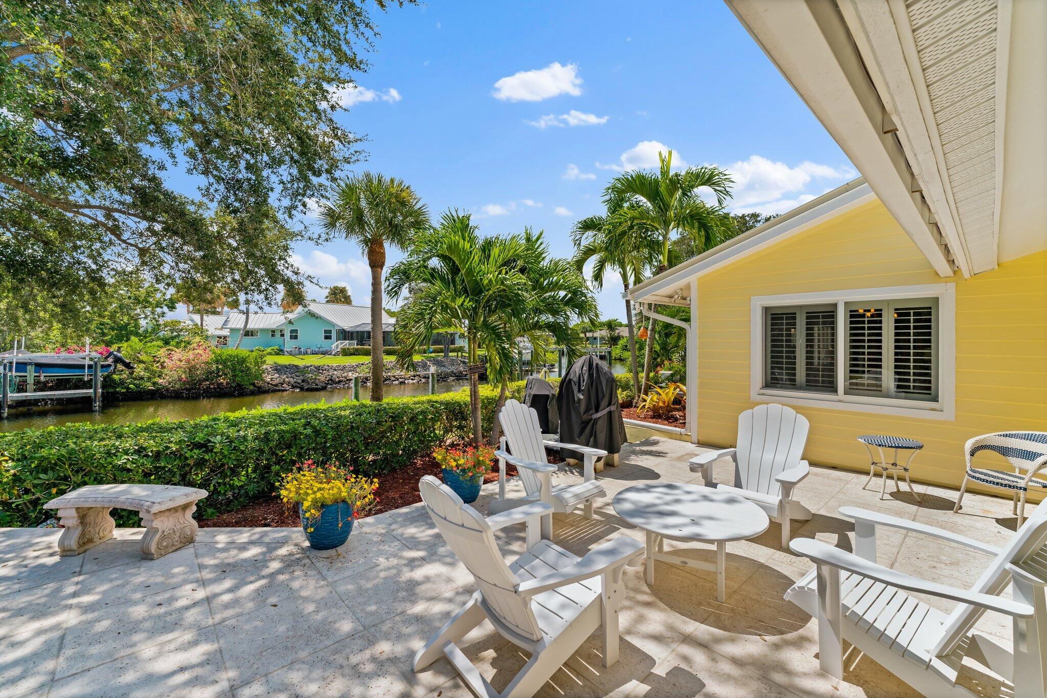 4120 Southeast Whiticar Way Stuart, FL 34997 - Photo 46 of 60 a view of a patio with table and chairs potted plants with wooden fence