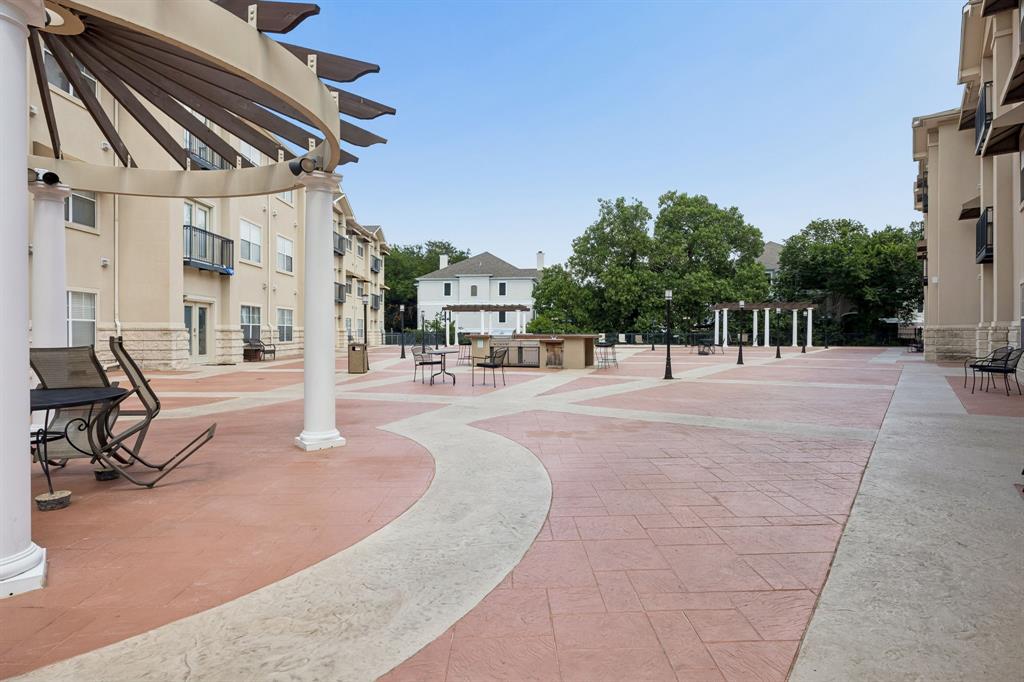 3102 Kings Road, Unit 1211 Dallas, TX 75219 - Photo 25 of 27 Expansive paved courtyard featuring decorative pergolas, outdoor lighting, and a built-in outdoor kitchen area