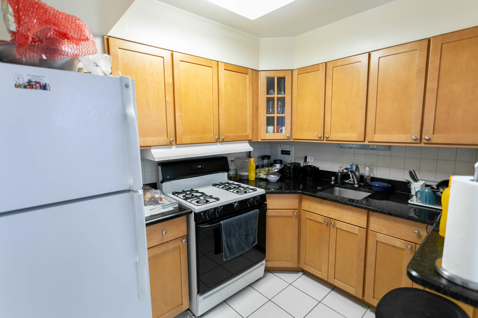 253 East Delaware Place, Unit 14C Chicago, IL 60611 - Photo 4 of 7 a kitchen with stainless steel appliances granite countertop a stove a sink and a refrigerator