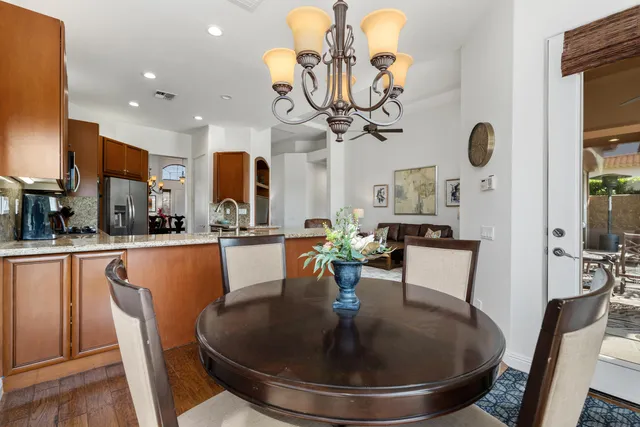 a dining room filled chandelier and kitchen view