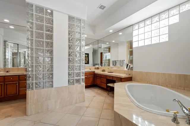 a bathroom with a tub sink and mirror