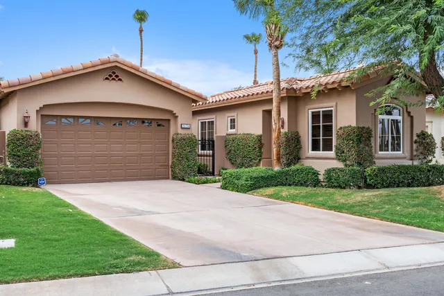 a front view of a house with a garden and yard