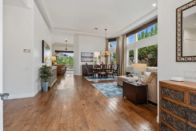 a living room with furniture a large window wooden floor and a rug