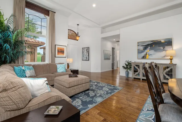 a living room with furniture wooden floor and a large window