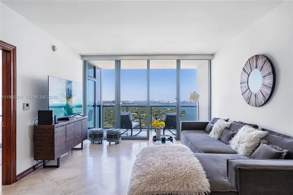 a living room with furniture and floor to ceiling windows