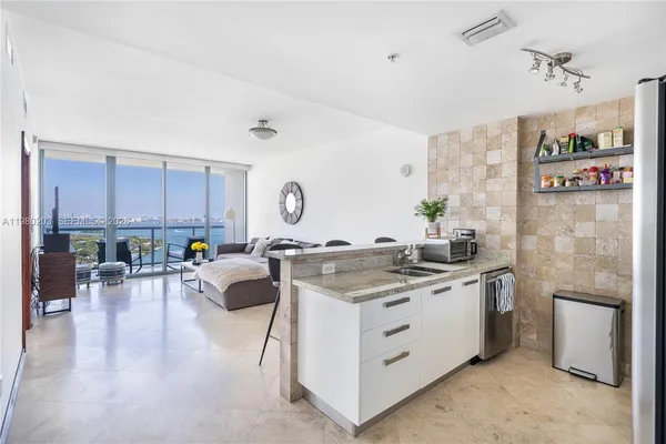 a view of kitchen with stainless steel appliances granite countertop a stove oven and a refrigerator with cabinets