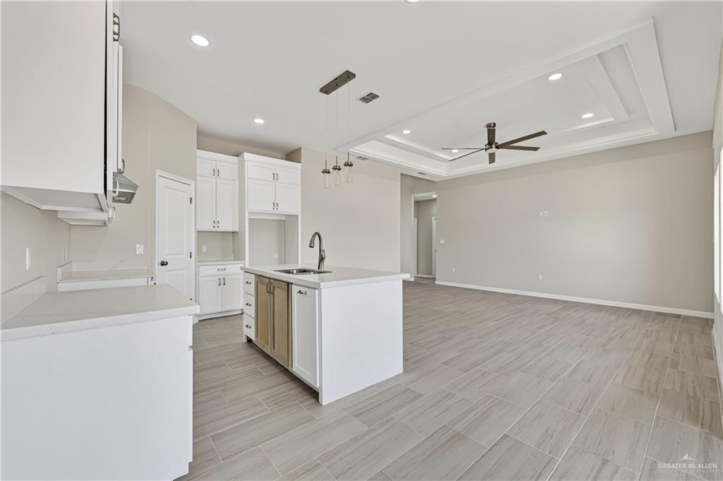 448 Sandy Road Donna, TX 78537 - Photo 5 of 14 Kitchen island with an undermount sink, a gooseneck faucet, and integrated cabinetry