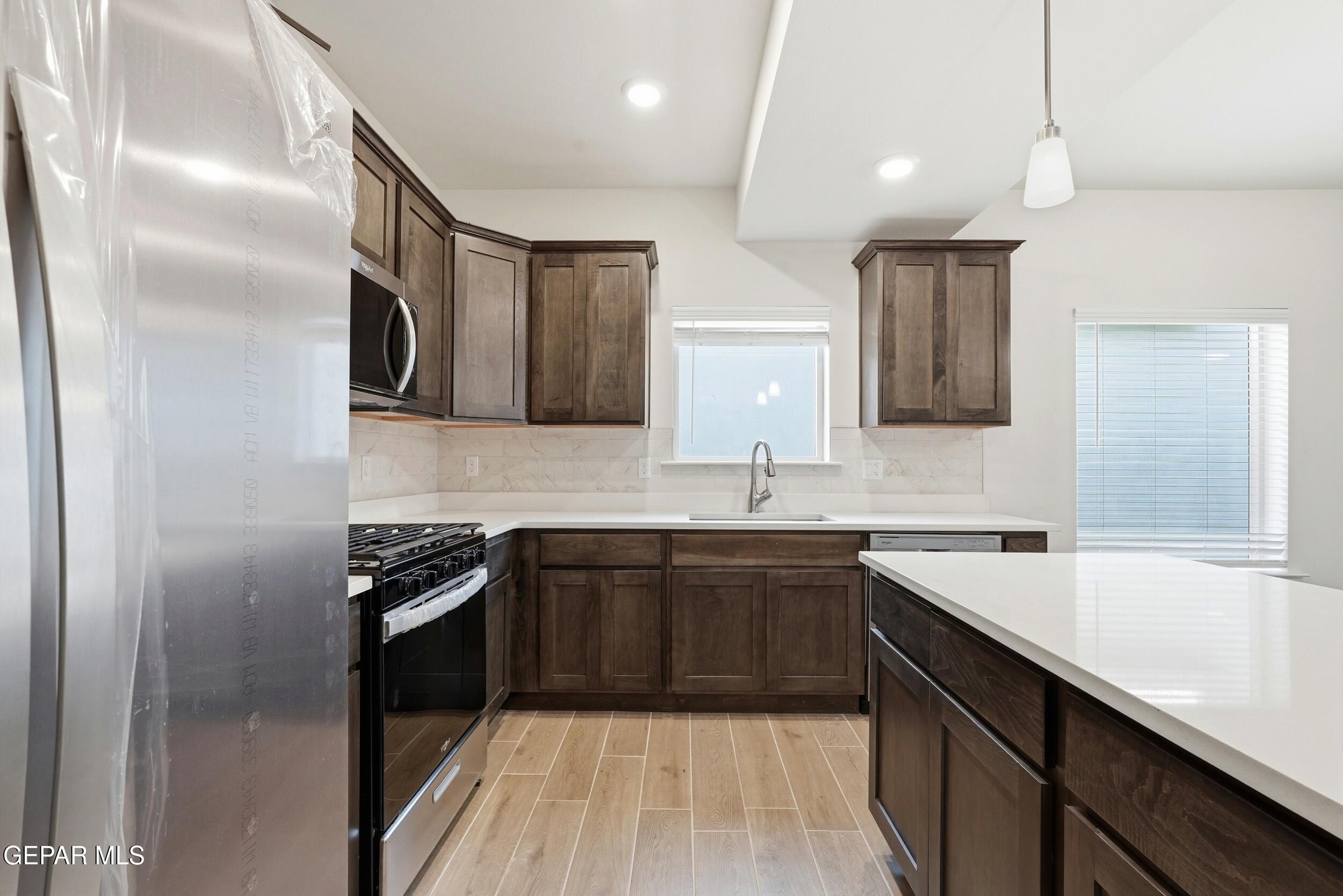 3764 Model Lane El Paso, TX 79938 - Photo 8 of 20 a kitchen with stainless steel appliances granite countertop a sink stove and refrigerator