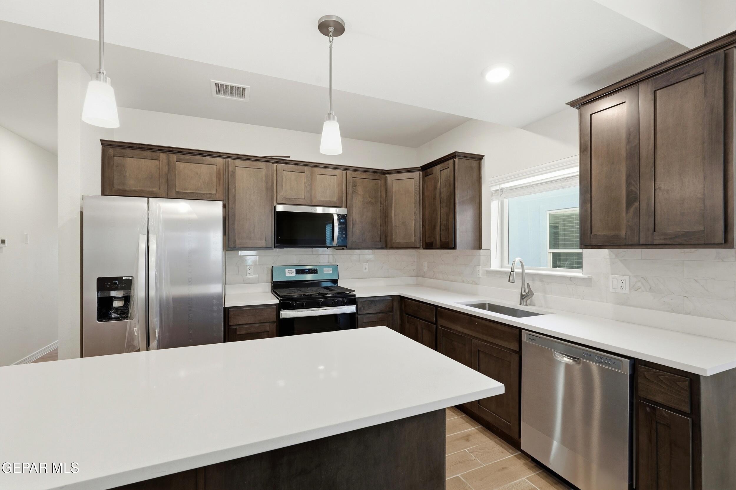 3764 Model Lane El Paso, TX 79938 - Photo 9 of 20 a kitchen with stainless steel appliances a refrigerator sink and microwave