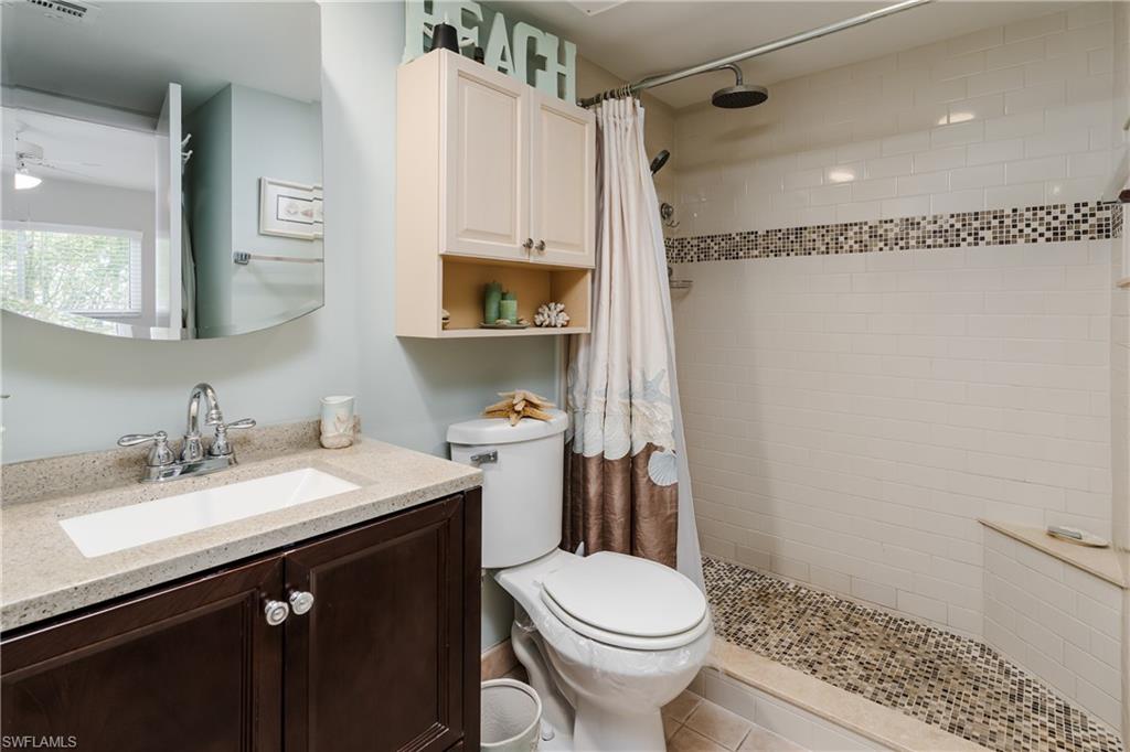 1014 Manatee Road, Unit F102 Naples, FL 34114 - Photo 16 of 36 a bathroom with a sink a toilet a mirror and shower