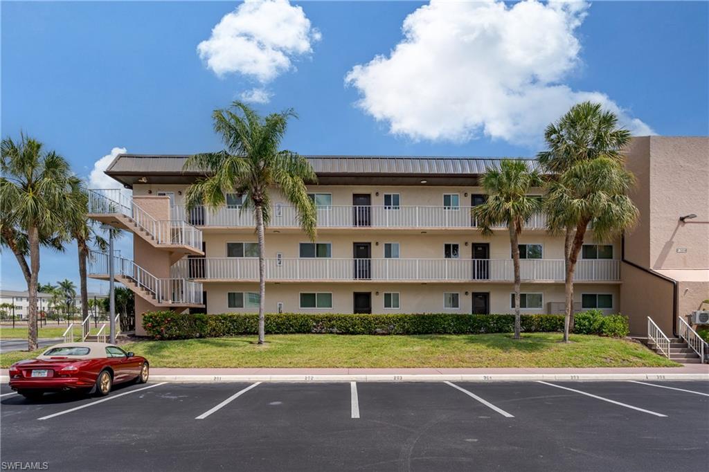 1014 Manatee Road, Unit F102 Naples, FL 34114 - Photo 2 of 36 a view of a parked cars in front of a building