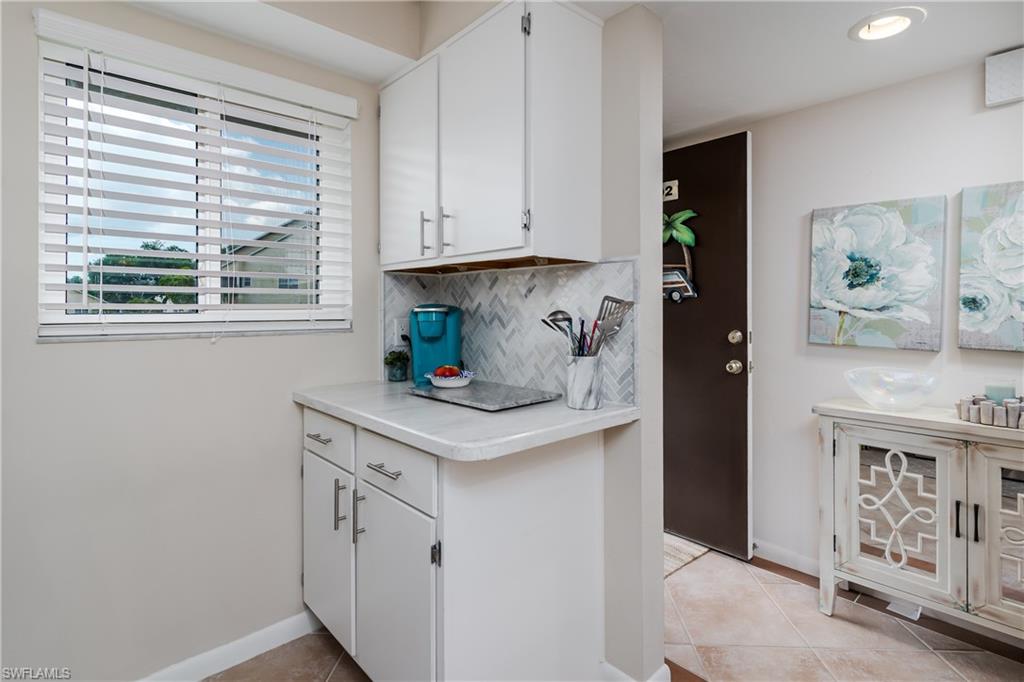 1014 Manatee Road, Unit F102 Naples, FL 34114 - Photo 5 of 36 a kitchen with stainless steel appliances white cabinets and a window