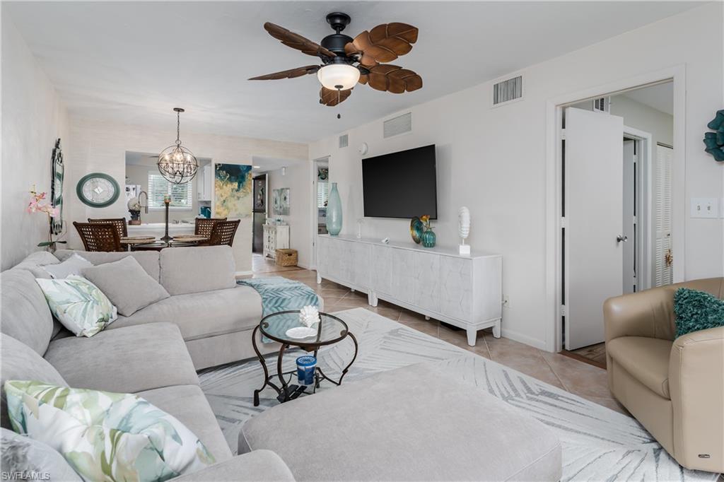 1014 Manatee Road, Unit F102 Naples, FL 34114 - Photo 9 of 36 a living room with furniture a ceiling fan a flat screen tv and a window