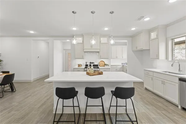 a kitchen with a dining table chairs and white cabinets