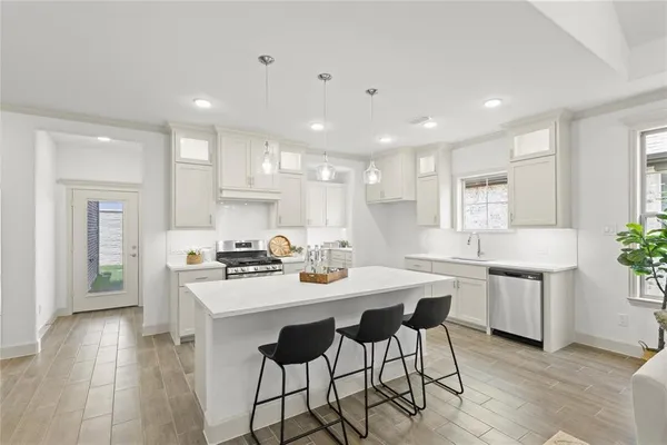 a kitchen with a dining table chairs stainless steel appliances and cabinets