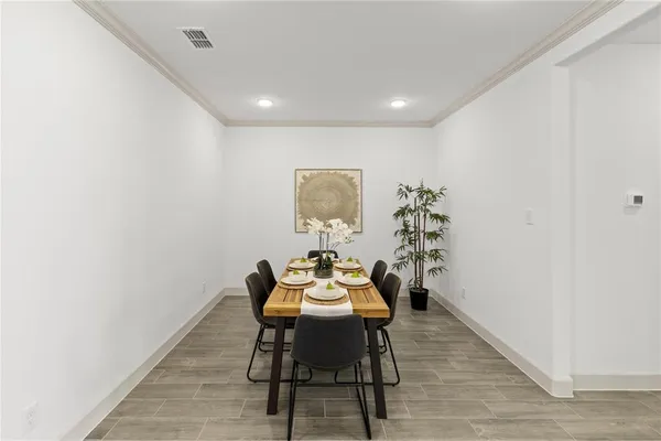 a open dining room with kitchen island stainless steel appliances wooden floor dining table and chairs