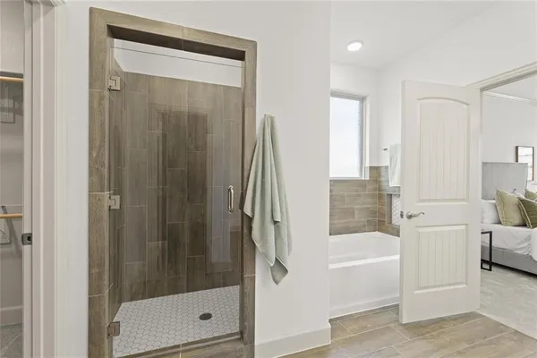 a en suite bathroom with a double vanity sink a mirror and a bathtub