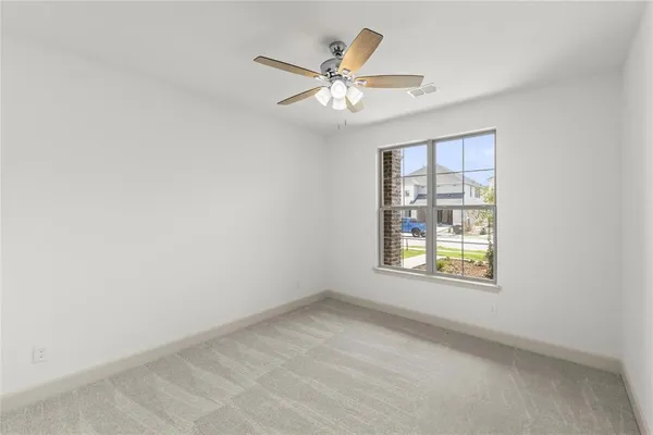 an empty room with windows and fan