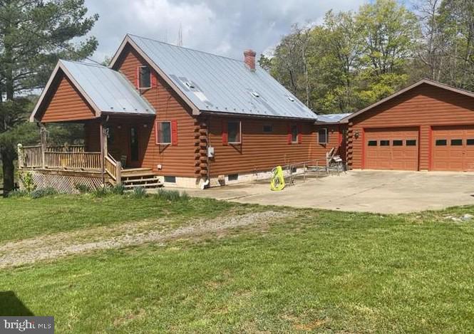 a front view of house with yard and trees in the background