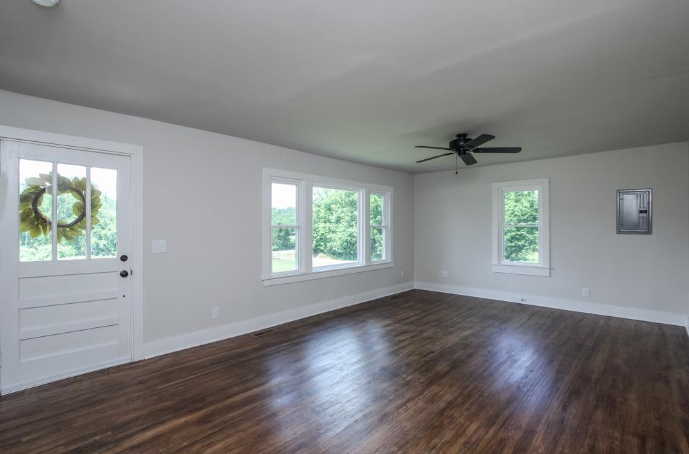 950 Owens Road Watertown, TN 37184 - Photo 19 of 30 an empty room with wooden floor windows and exposed bricks