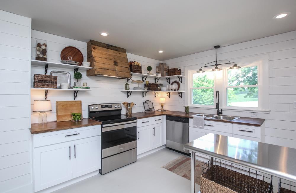 950 Owens Road Watertown, TN 37184 - Photo 3 of 30 a kitchen with stainless steel appliances granite countertop a stove a sink dishwasher and white cabinets with wooden floor
