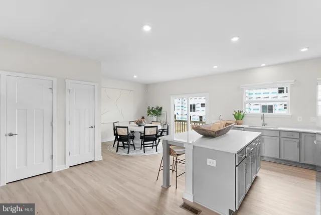 a kitchen that has a sink a table and chairs in it