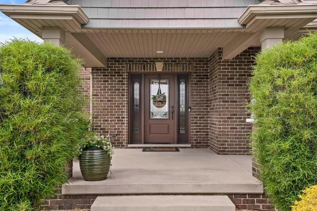 an aerial view of a house with huge green field and fence