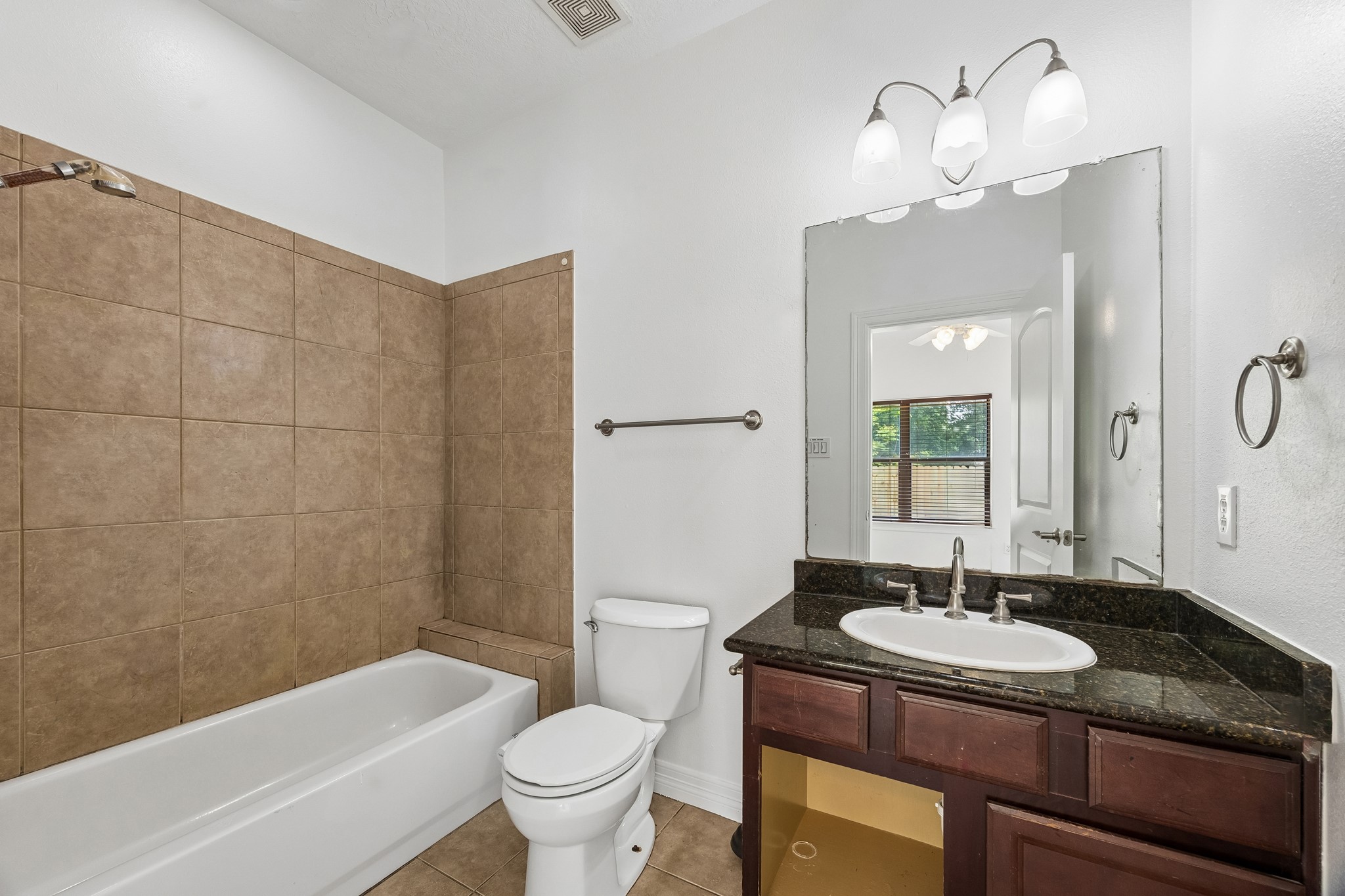 4102 Bonner View Lane Houston, TX 77007 - Photo 8 of 14 a bathroom with a granite countertop sink a toilet a mirror and bathtub