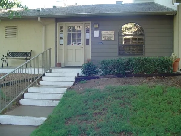 a view of a brick house with a yard and plants