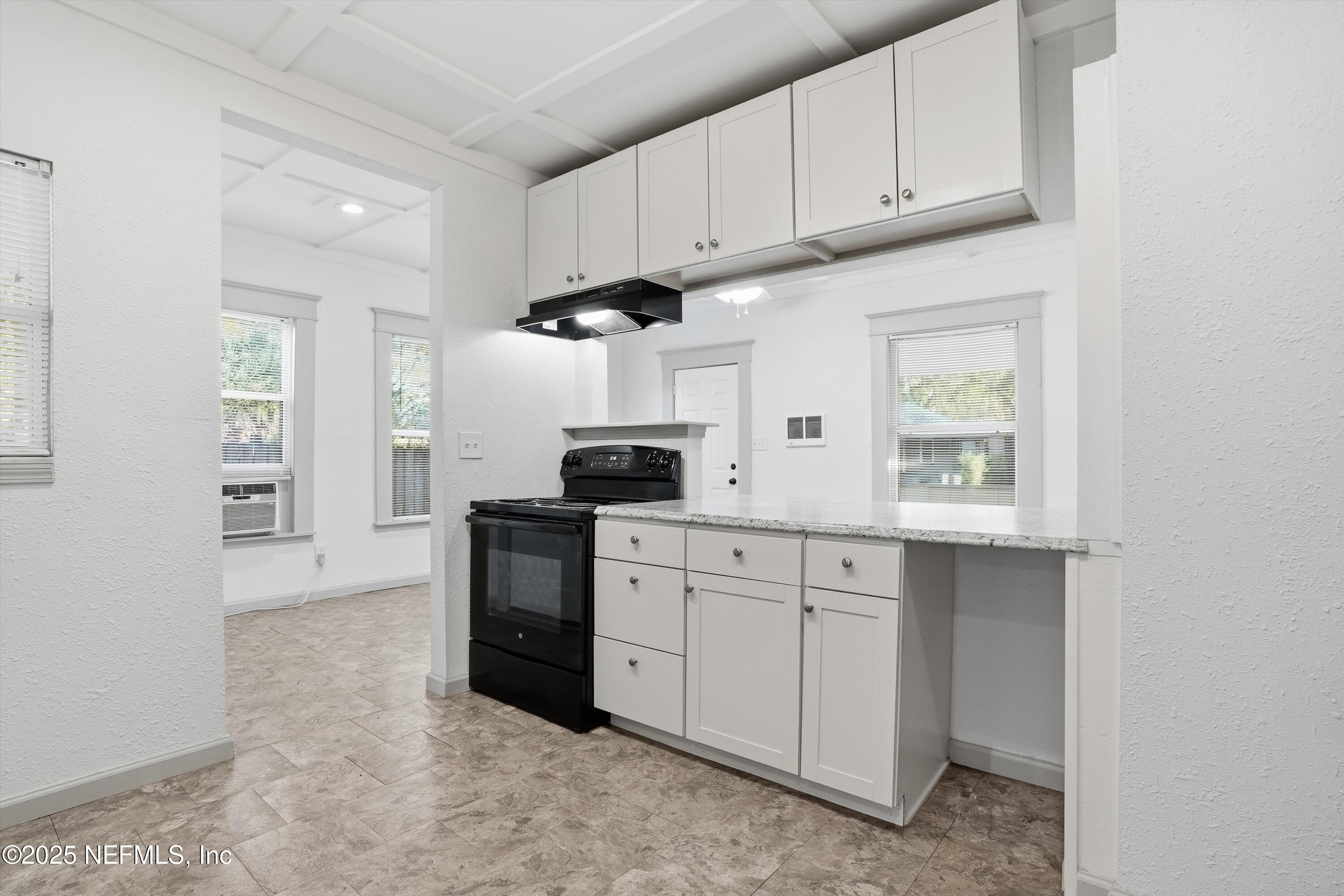 911 Phillips Street Jacksonville, FL 32207 - Photo 12 of 36 a kitchen with white cabinets and appliances