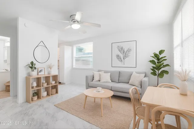 a living room with furniture a table and a potted plant