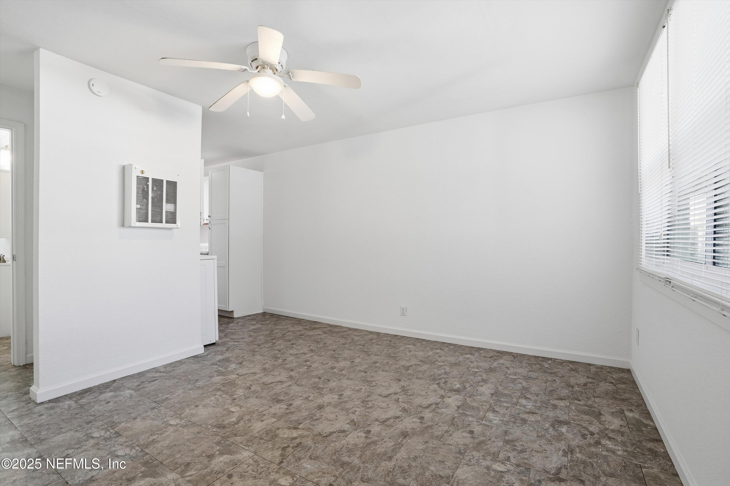 911 Phillips Street Jacksonville, FL 32207 - Photo 21 of 36 an empty room with windows and chandelier fan