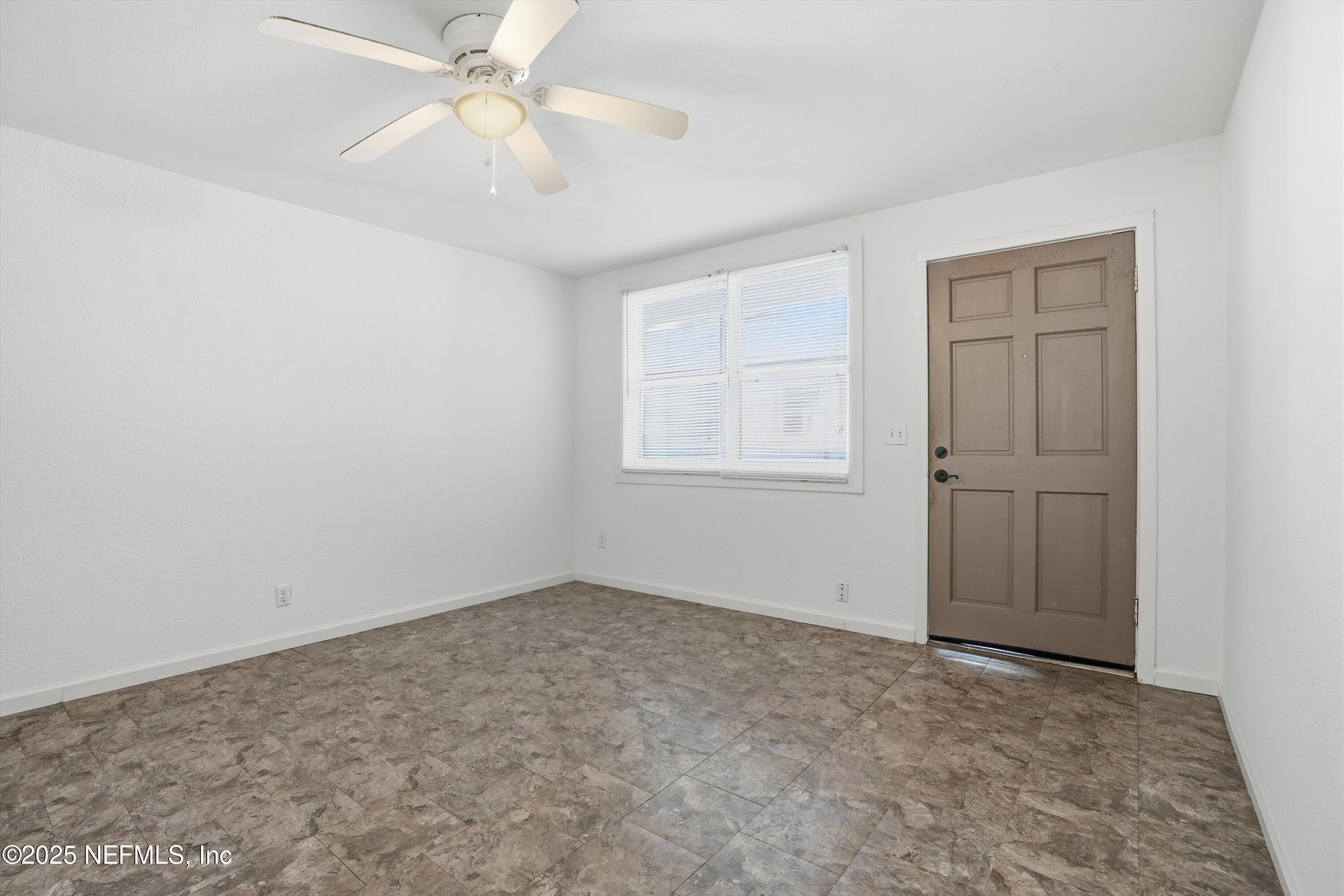 911 Phillips Street Jacksonville, FL 32207 - Photo 22 of 36 an empty room with chandelier fan and windows