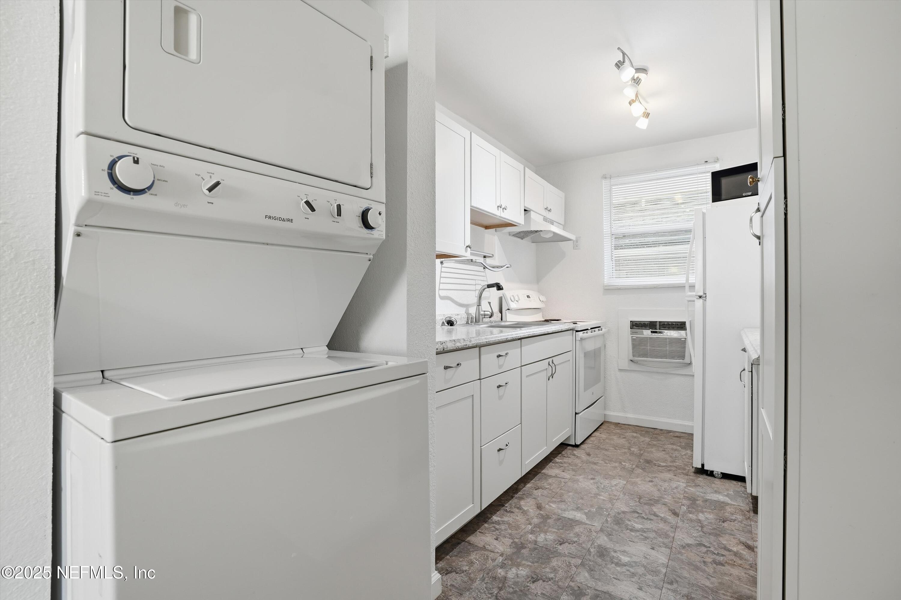 911 Phillips Street Jacksonville, FL 32207 - Photo 24 of 36 a utility room with cabinets washer and dryer