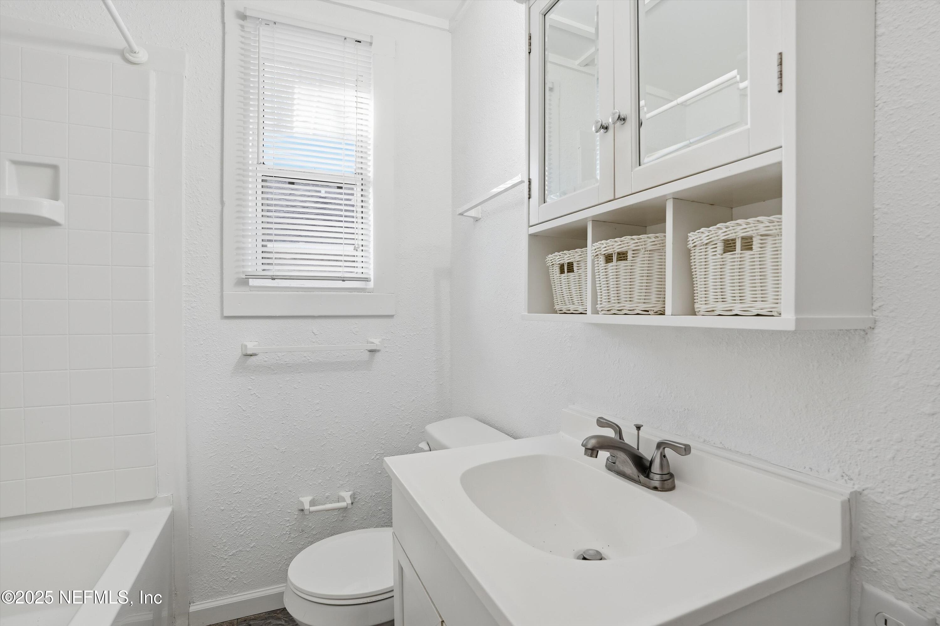 911 Phillips Street Jacksonville, FL 32207 - Photo 25 of 36 a bathroom with a sink a toilet and mirror
