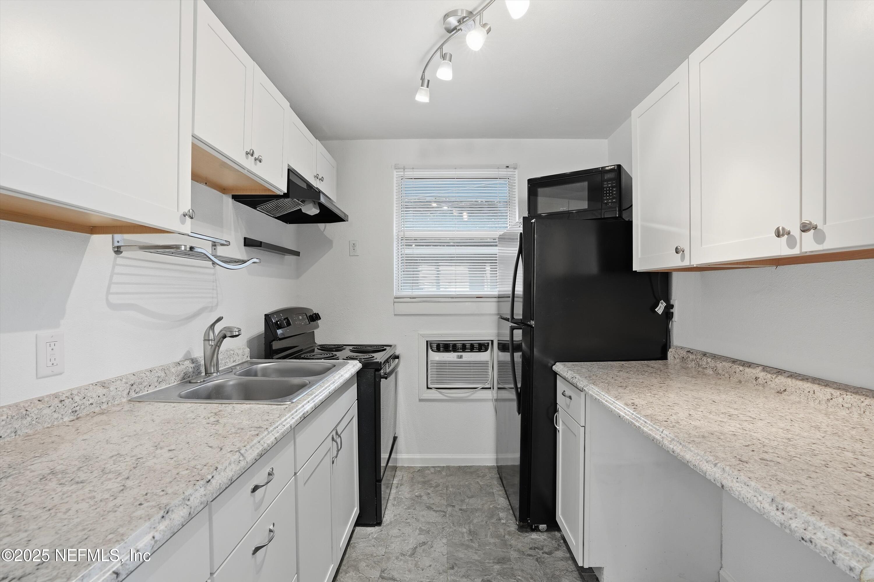 911 Phillips Street Jacksonville, FL 32207 - Photo 28 of 36 a kitchen with granite countertop a sink stove and refrigerator