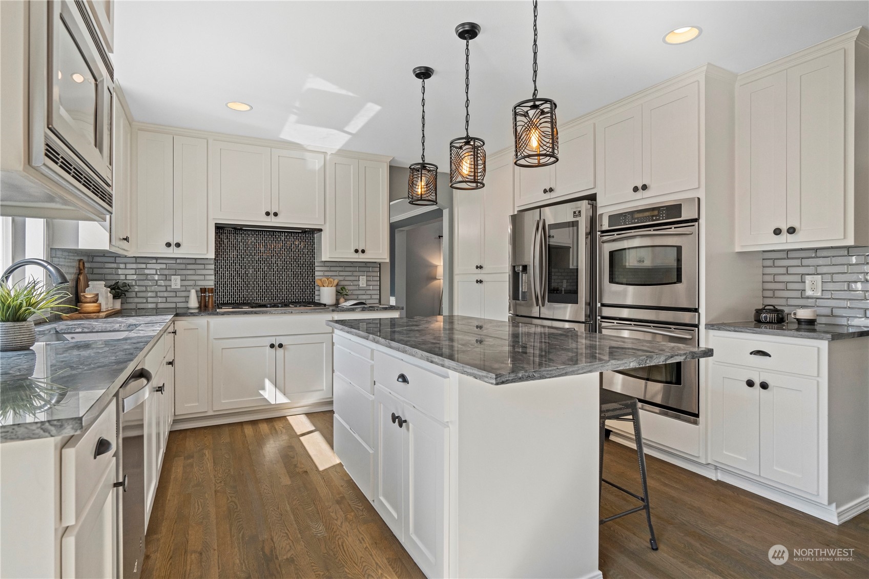 4410 239th Place Southeast Bothell, WA 98021 - Photo 9 of 40 a kitchen with stainless steel appliances kitchen island granite countertop a stove a sink and a refrigerator