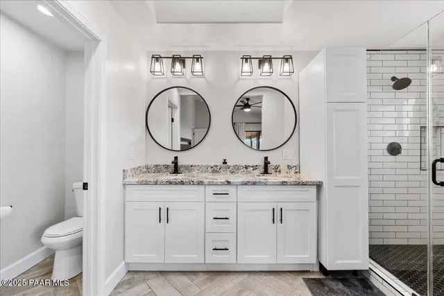 a bathroom with a granite countertop double vanity sink and a mirror