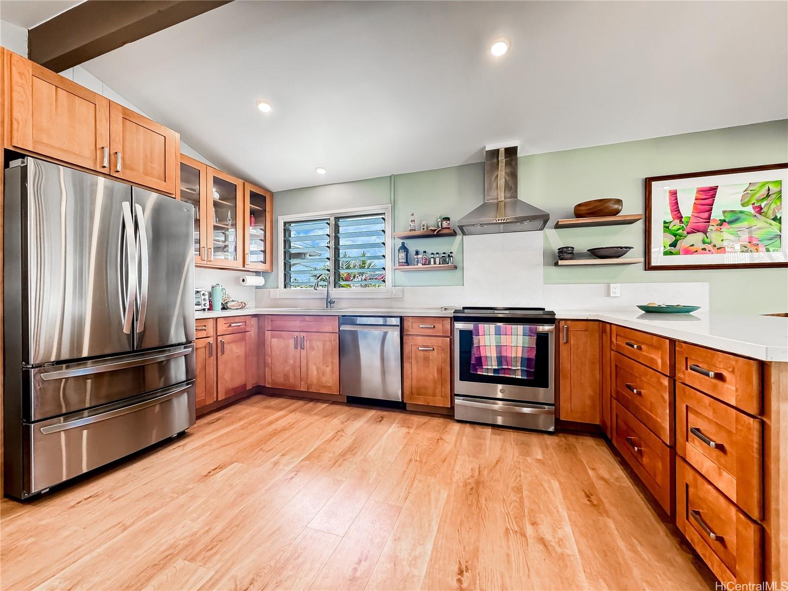 a kitchen with stainless steel appliances granite countertop a refrigerator a stove and a wooden floors
