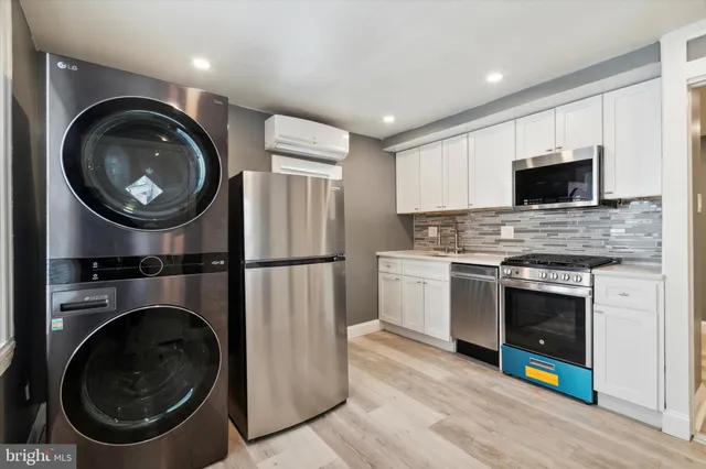a kitchen with a stove a washer and a microwave
