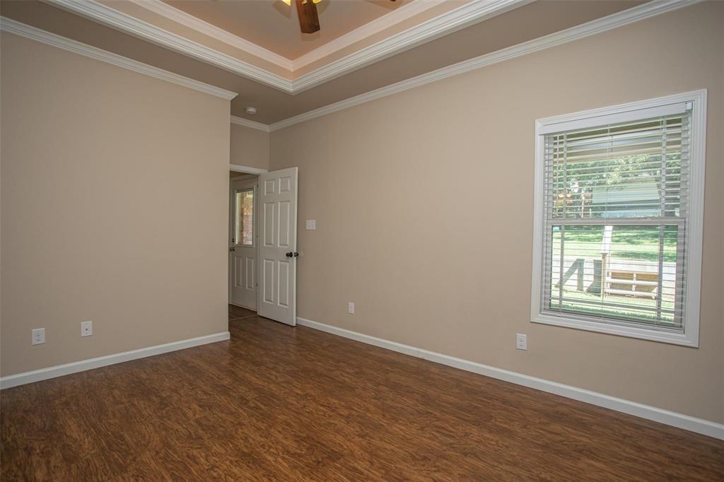 455 Neals Hill Road Oak Ridge, TX 76240 - Photo 16 of 19 Empty room featuring dark wood-type flooring, crown molding, and ceiling fan