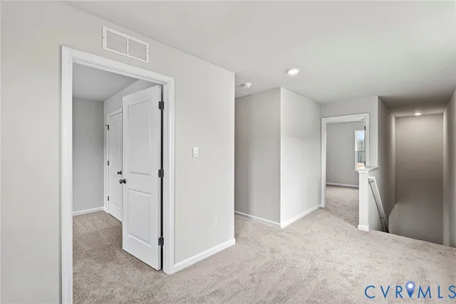 a view of a hallway with closet and wooden floor
