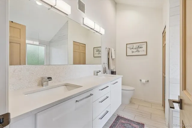 a spacious bathroom with a toilet sink and mirror
