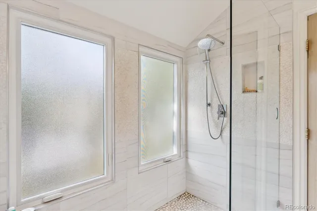 a bathroom with a glass shower door and a window