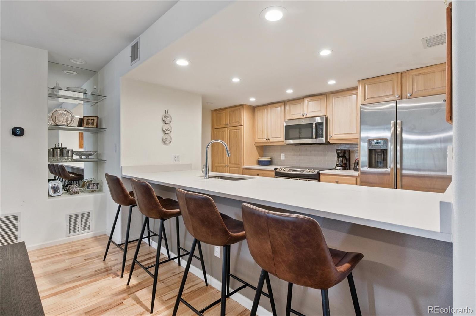 23666 Pondview Place, Unit H Golden, CO 80401 - Photo 7 of 19 a kitchen with stainless steel appliances granite countertop a stove a sink a refrigerator with a dining table and chairs