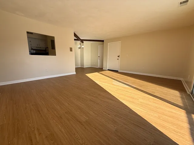 a view of an empty room with wooden floor