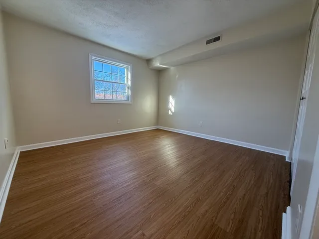 a view of a room with wooden floor and white walls